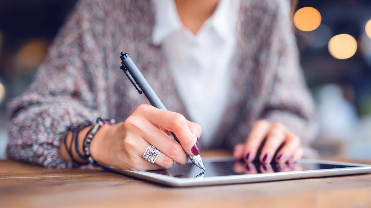 Dokumentation: Eine Psychotherapeutin erstellt einen Hausarzt-Bericht digital auf einem Tablet.