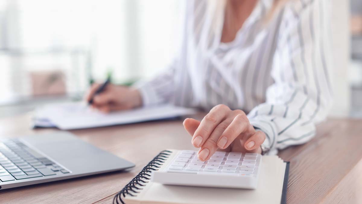 Eine Psychotherapeutin berechnet von ihr erbrachte Leistungen mit Laptop und Taschenrechner. Moderne Praxissoftware-Lösungen unterstützen Psychotherapeuten während der gesamten KV-Abrechnung.